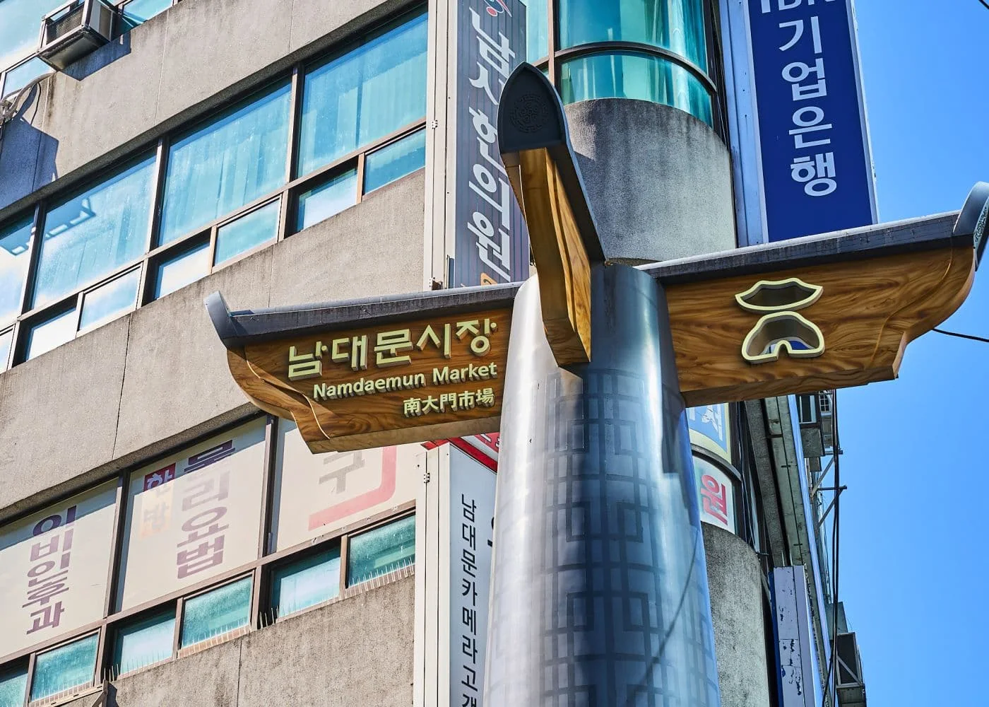 남대문 시장의 풍경, 양옆 건물들 1층에는 시장 상점들이 있고 도로에는 사람들이 지나다니는 모습